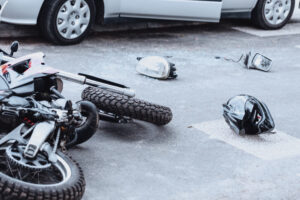 Car mirror, headlight, helmet and motorcycle lying on the road after a car crash